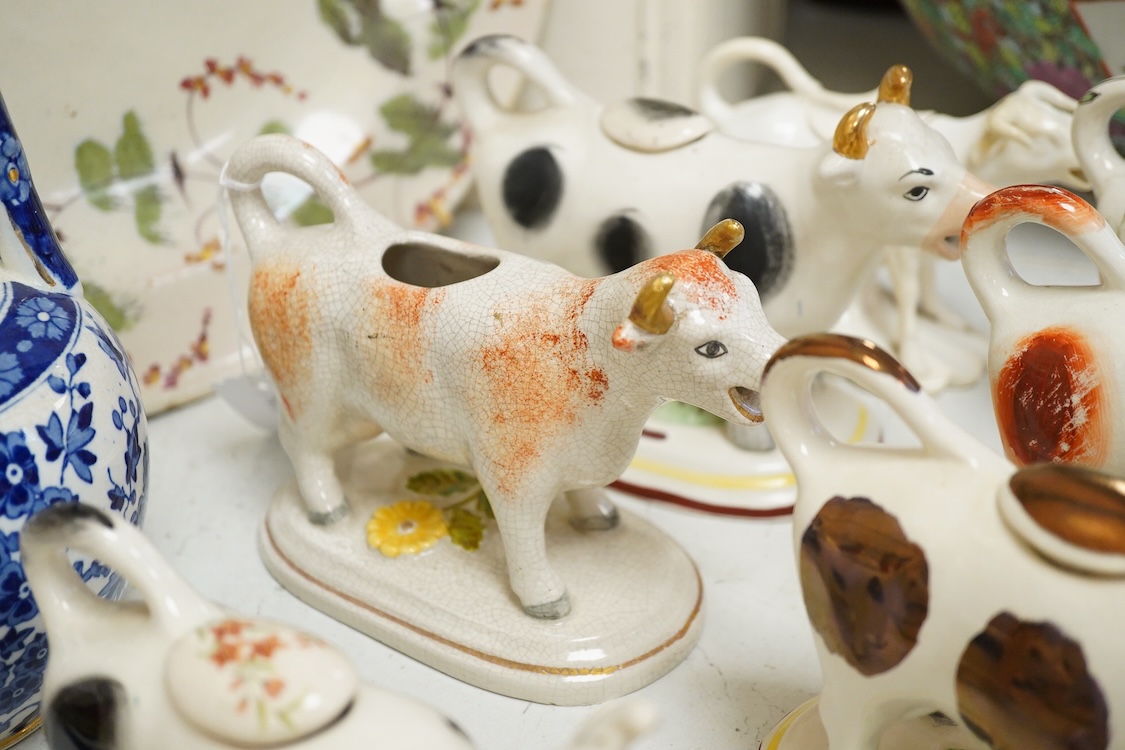 A large collection of English pottery cow creamers, Staffordshire figures and cruets a blue and white teapot and sponge ware dish-34cm diameter, (26)